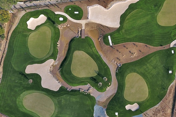 Aerial view of custom putting green turf installation featuring contoured synthetic greens, sand bunkers, and surrounding fairway turf for a realistic golf course design.